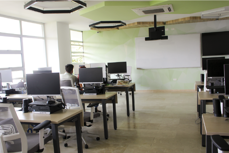 The School of Mathematics invites you to get to know its Computer Lab 506, which is available to its students and the educational community. Photo taken at the School of Mathematics, general view of the room where you can see a student working on the computer.
