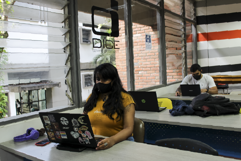 The School of Industrial Design invites you to get to know its Center for Industrial Design Studies (DICE), which is available to its students and the educational community. The photo is a close-up of two students working at their respective desks.