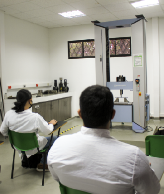 It is important for the School of Metallurgical Engineering and Materials Science to show the facilities at the service of the students and the university community. Photo taken at the School, in a general shot of a room where several students are looking at a machine in the laboratory.