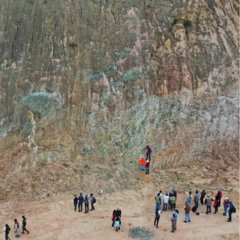 The School of Geology presents its research groups to the educational community and the general public. Photo provided by the school, general shot showing a group of people standing at the bottom of a mountain.
