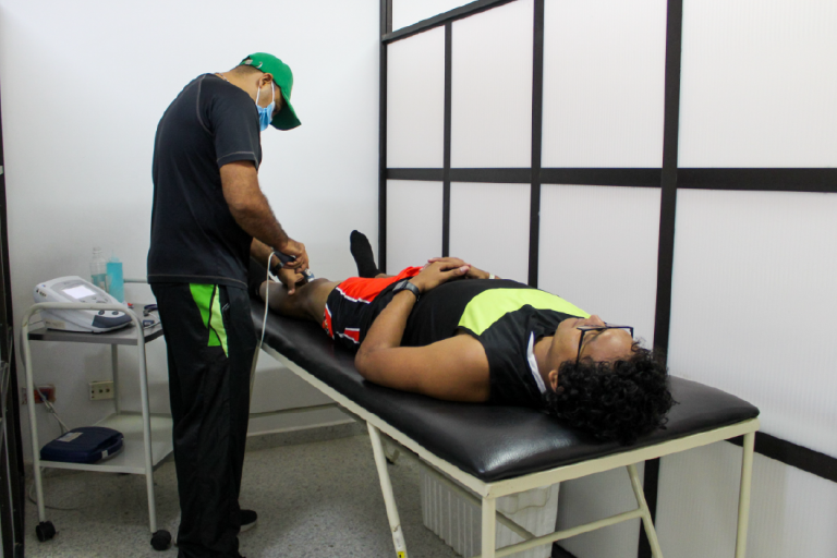 The Physical Education and Sports Department UIS invites you to get to know its Sports Physiotherapy Laboratory. General plan of the sports training where the therapist appears doing therapy with one of the students, who is lying on a stretcher.