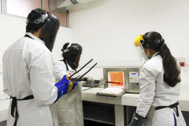 The School of Metallurgy and Materials Science invites you to get to know its Heat Treatment Laboratory, which is at the disposal of its students and the educational community. Photo taken at the School, in a general shot showing three students taking a piece out of the metal furnace.
