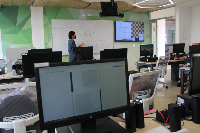 The School of Mathematics invites you to get to know its Computer Lab 505, which is available to its students and the educational community. Photo taken at the School of Mathematics, general view of the room where you can see a student making an exhibition.